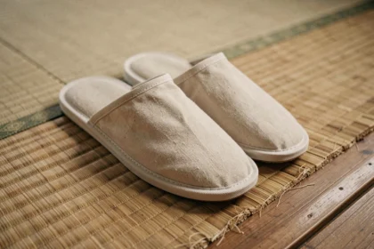 Paire de chaussures traditionnelles japonaises uwabaki posées au bord d'un tatami en paille tressée dans une pièce japonaise authentique